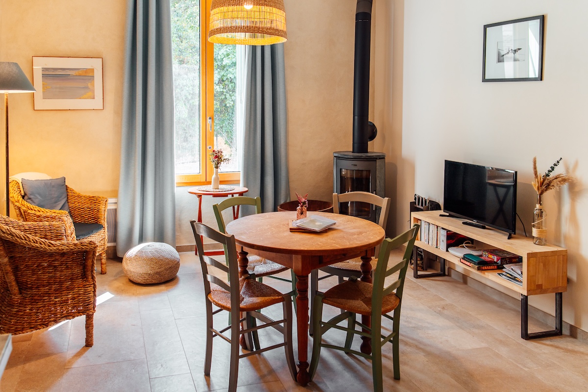 Salon et salle à manger du gîte cocooning Le salon et salle à manger du gîte avec son poêle à bois pour une ambiance cocooning