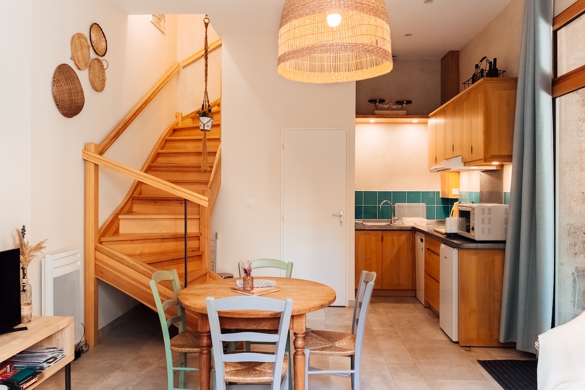 Cuisine et salle à manger pour 2 au gîte Le joli séjour avec son escalier en bois, sa cousine bleue