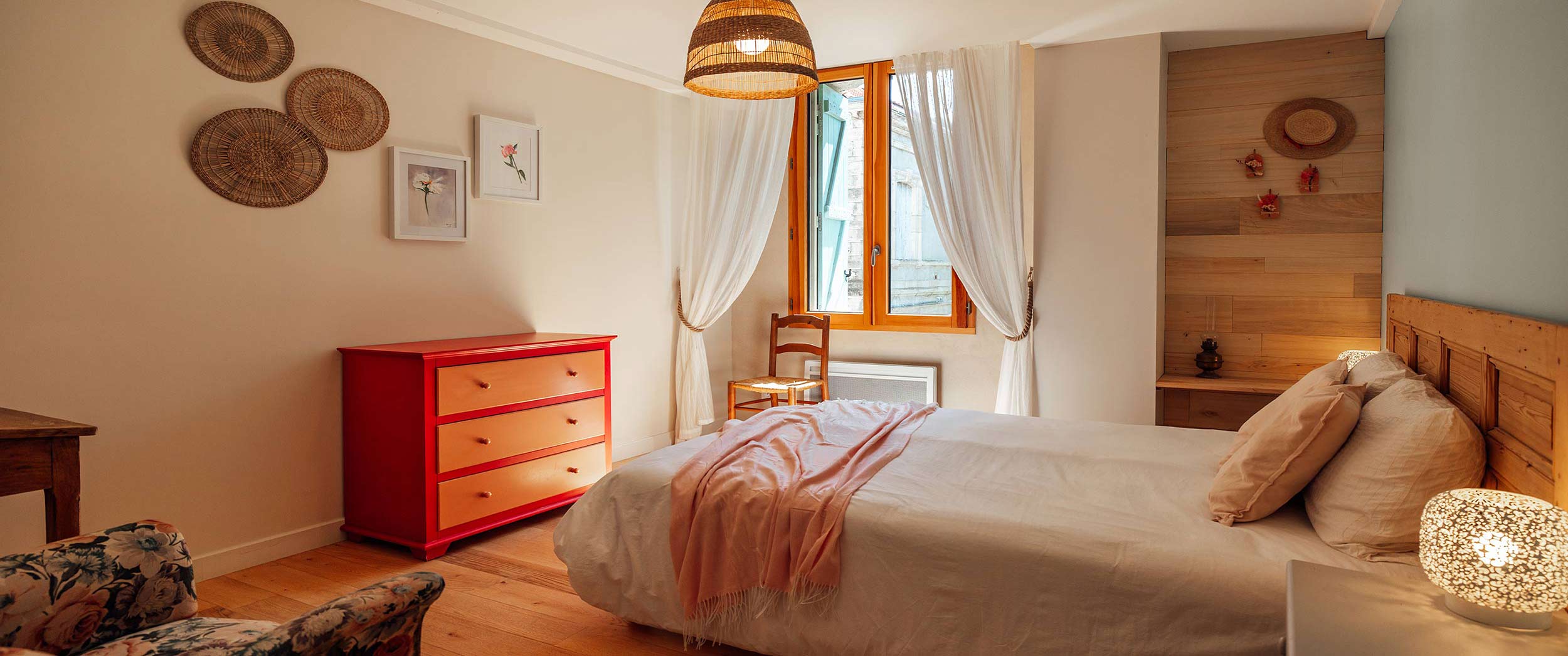 La jolie chambre aux couleurs rouge et rose avec mobilier chinée et vue sur le domaine viticole